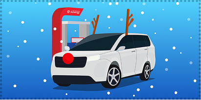 A white SUV at a fuel pump with reindeer antlers and a red nose, surrounded by snow.